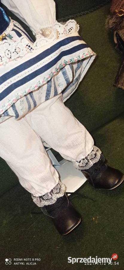 Lalka z kokardą we włosach i krzyżykiemLalka