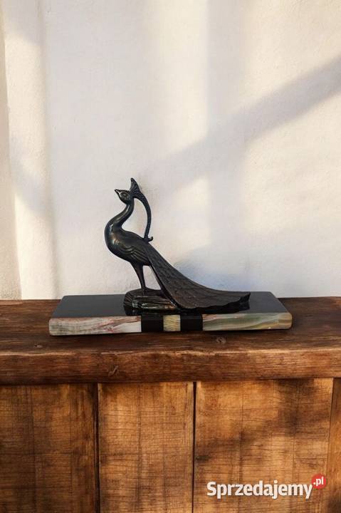 metalowa figura pawia na marmurowoonyksowej