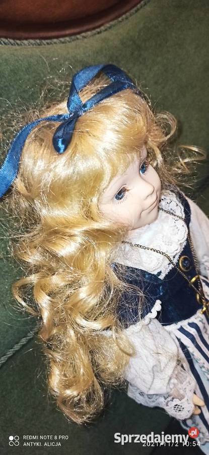 Lalka z kokardą we włosach i krzyżykiemLalka Porcelana i szkło