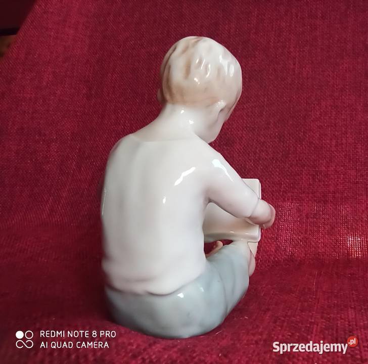 Figurka siedzącego chłopca czytającego książkę Porcelana i szkło Gdańsk