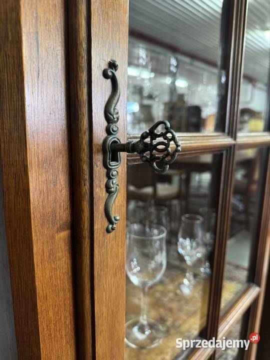 Wąska przeszklona witryna z drewnianymi półkami