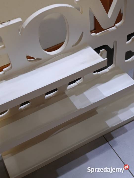 biała drewniana dekoracja stojąca z napisem Home Poznań