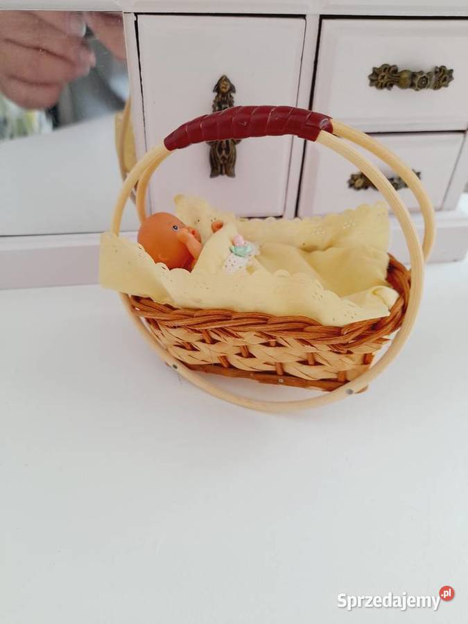 Zabytkowa kołyska wiklinowa z laleczką