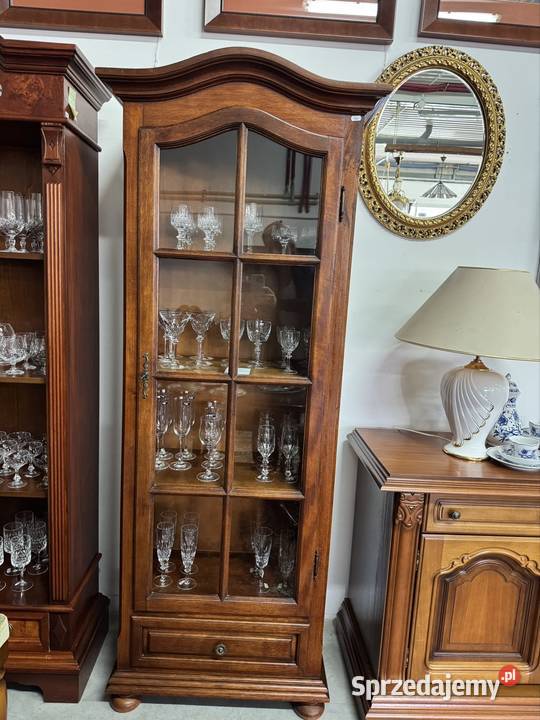 Wąska przeszklona witryna z drewnianymi półkami