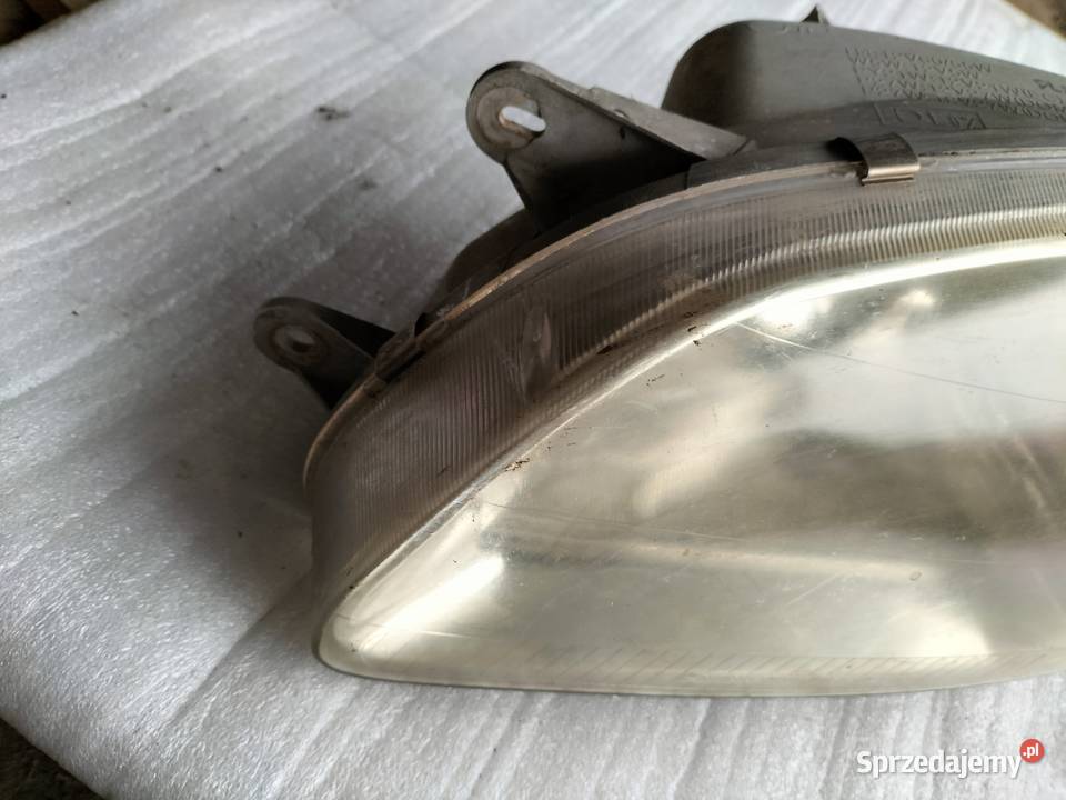 KIA CARNIVAL LAMPA PRZÓD PRZEDNIA LEWA Lewe Kamień-Kolonia