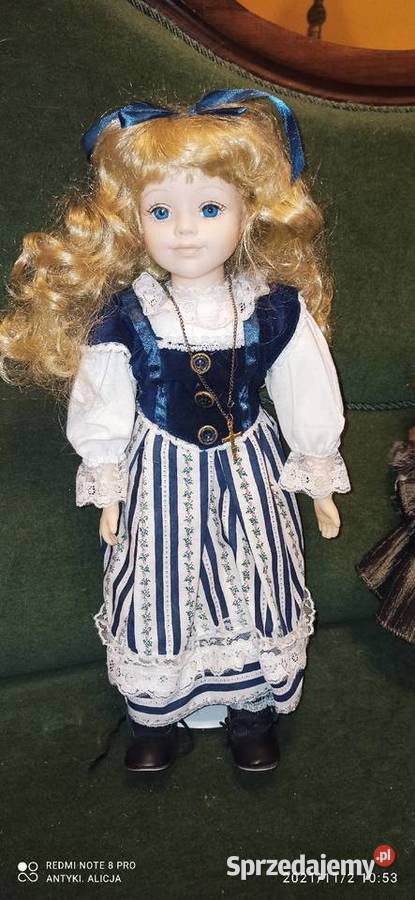 Lalka z kokardą we włosach i krzyżykiemLalka