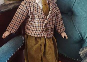 Lalka z kokardą we włosach i krzyżykiem.  Lalka kolekcjoners