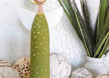 Anioł w zielonej sukience ze złotymi zdobieniami.