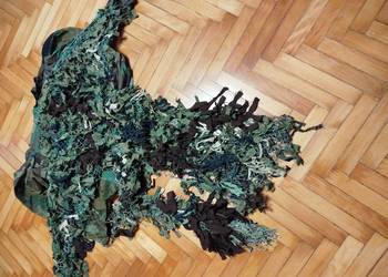 Kurtka polowa z naszytymi kawałkami siatki maskującej. Zapinana na rzepa