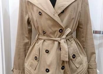 Klasyczny, beżowy płaszcz trencz z pomarańczową podszewką