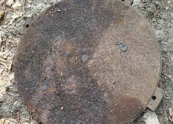 Żeliwne włazy, okrągłe tarcze robocze starej maszyny, płyty żelazne