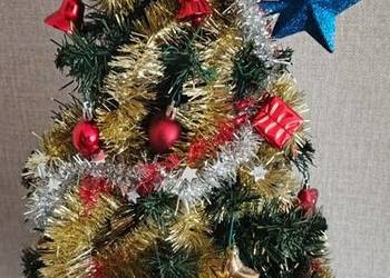 Sztuczna choinka z lampkami i bombkami.