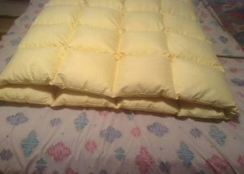 Gruba kołdra pikowana z pierza we wsypie.