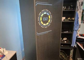 Nowoczesna szafa z półkami i efektownymi detalami inspirowanymi grami