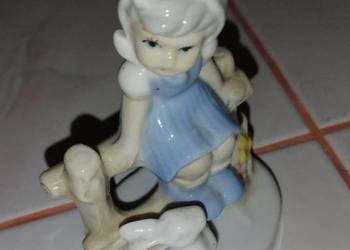 Dziewczynka na ławce z zajączkiem z porcelany