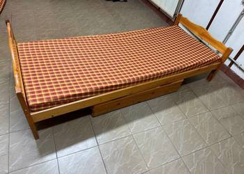 Łóżka drewniane z materacem i półką