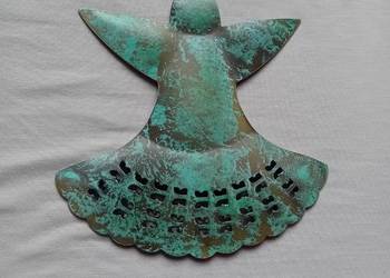 Metalowa zawieszka w formie aniołka, pokryta galwanicznie warstwą mosiądzu.