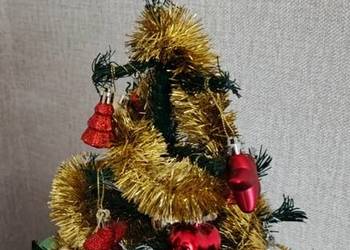 Mała sztuczna choinka z bombkami i oświetleniem.