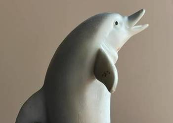 Figurka delfina. Na rafie, muszelkach. Na drewnianej podstaw Figurka delfina. Na rafie, muszelkach. Na drewnianej podstaw