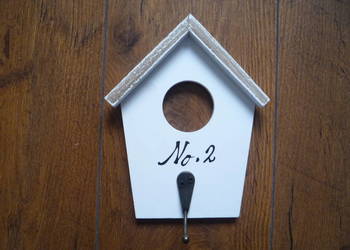 Biały wieszak na kurtki w kształcie domku