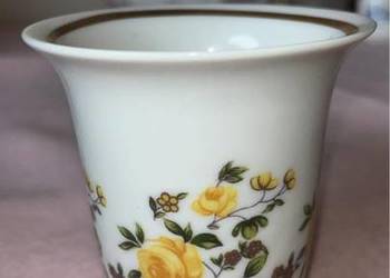 Z białej porcelany, wazonik. Z żółtymi różami.   Na postumencie.  Biała por