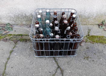 Stare butelki w drucianej kracie.