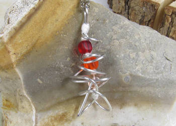 Abstrakcyjny wisiorek z drutu oraz czerwonych i pomarańczowych kostek