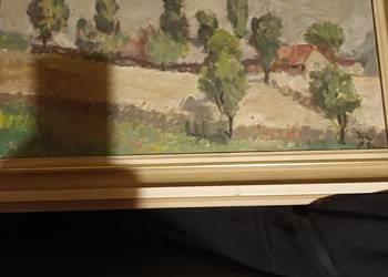 Zabudowy wiejskie wśród drzew w otoczeniu złotych pol pszenicy