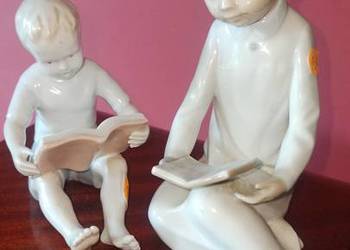 Figurka siedzącego chłopca czytającego książkę.