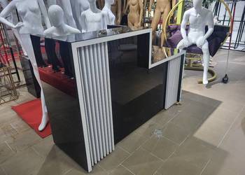 Nowoczesna lada recepcyjna pokryta czarnym szkłem