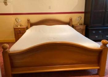 Dębowe łóżko do sypialni z materacami i szafkami.