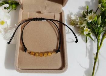 Bransoletka na sznurku z naturalnym bursztynem i złotym hematytem.