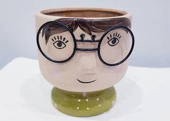 Ceramiczna osłonka na doniczkę sukulenta. Chłopiec w okularach