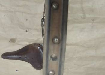 Drewniane stare koło rowerowe i siodełko.