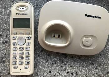 Telefon bezprzewodowy Panasonic ze stacją bazową i zasilaczem.