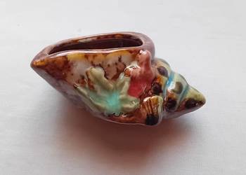 Ceramiczny szkliwiony pojemnik w formie muszli.