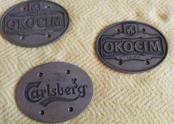 Metalowe emblematy browarów OKOCIM i CARLSBERG